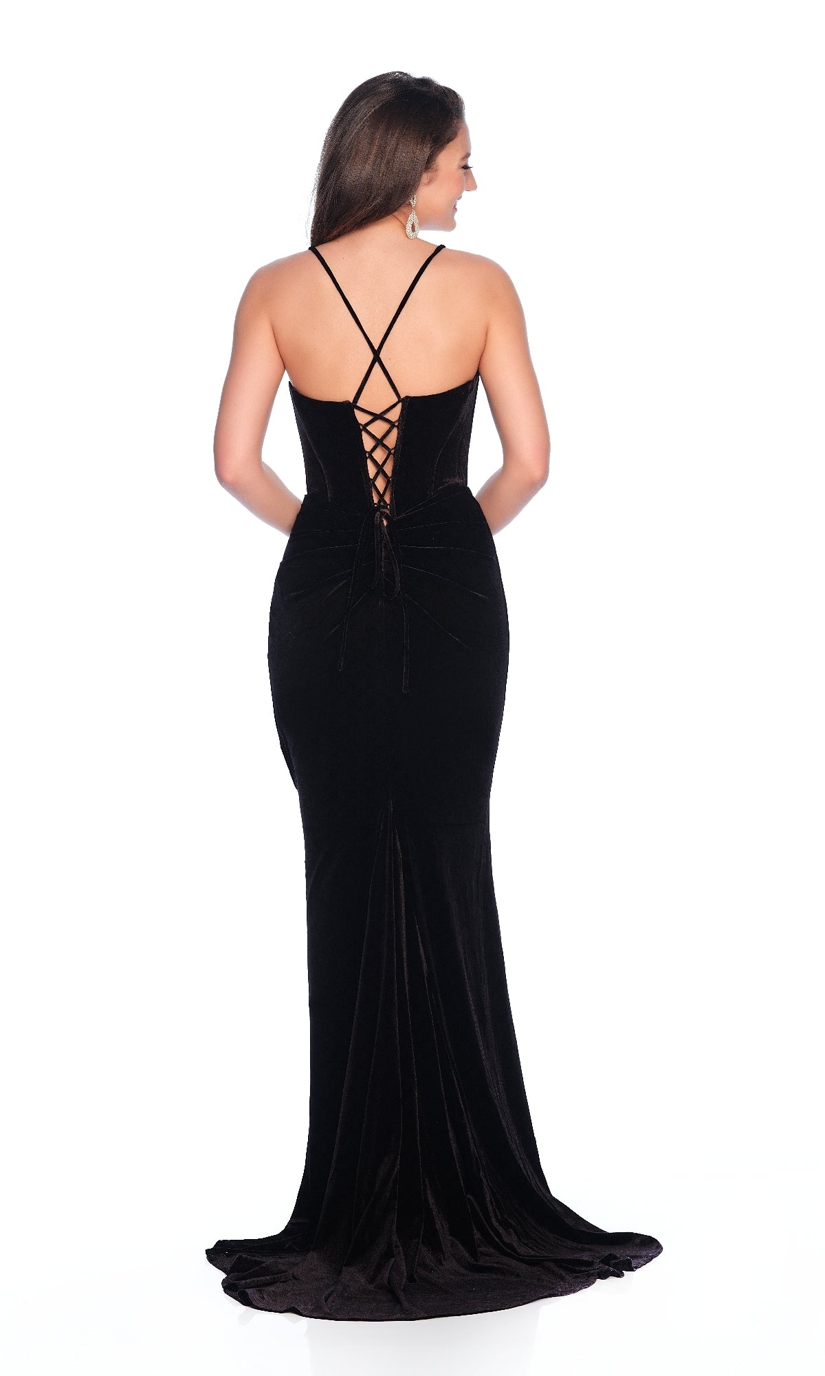 A woman stands against a white background wearing the Dave and Johnny 12216 long black velvet prom dress, featuring crisscross spaghetti straps and a lace-up back.